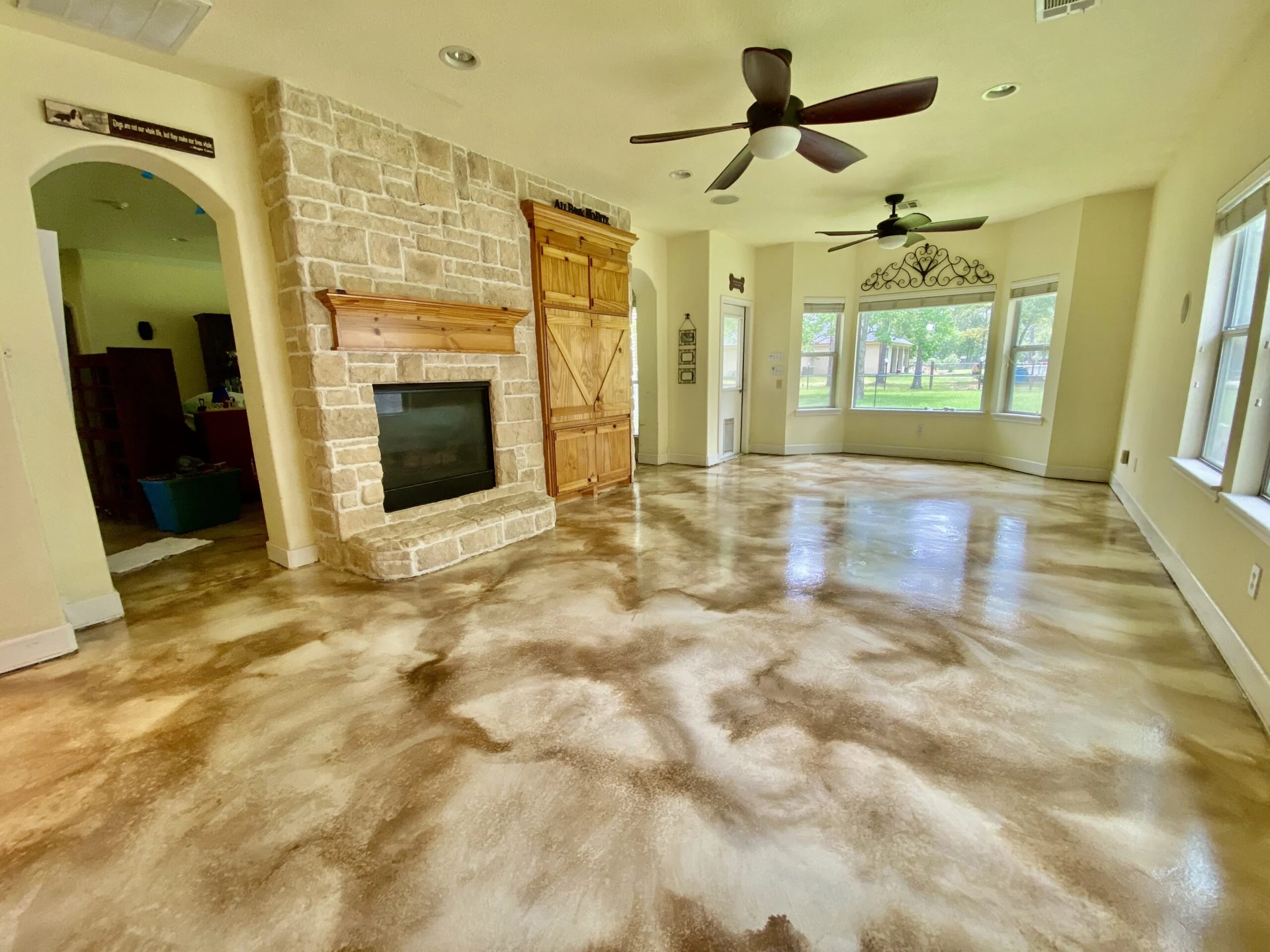 Metallic epoxy floor in a living room with a stone fireplace