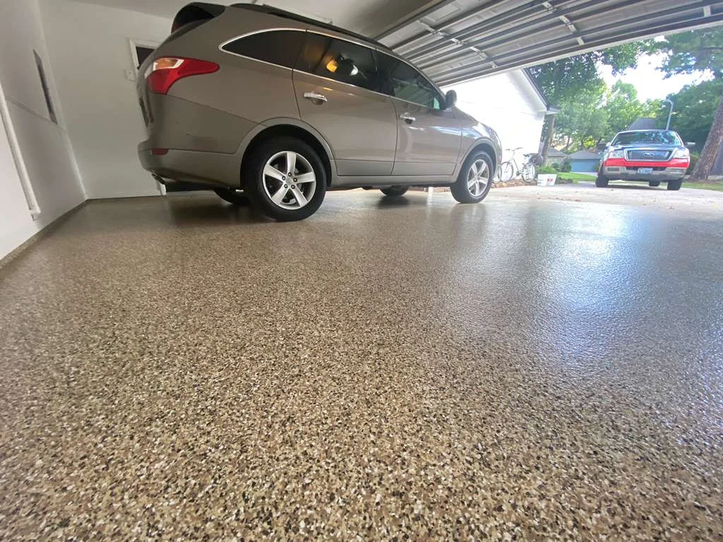 Epoxy flake garage floor with a parked car