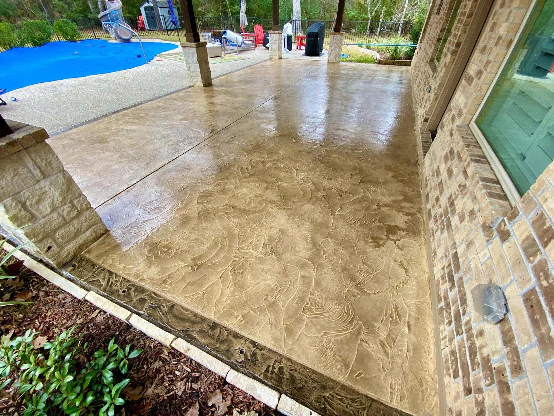 Decorative concrete patio beside a pool