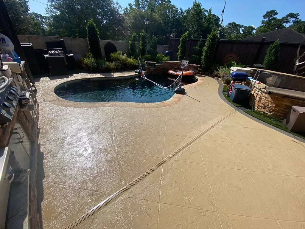 Textured concrete patio surrounding a swimming pool