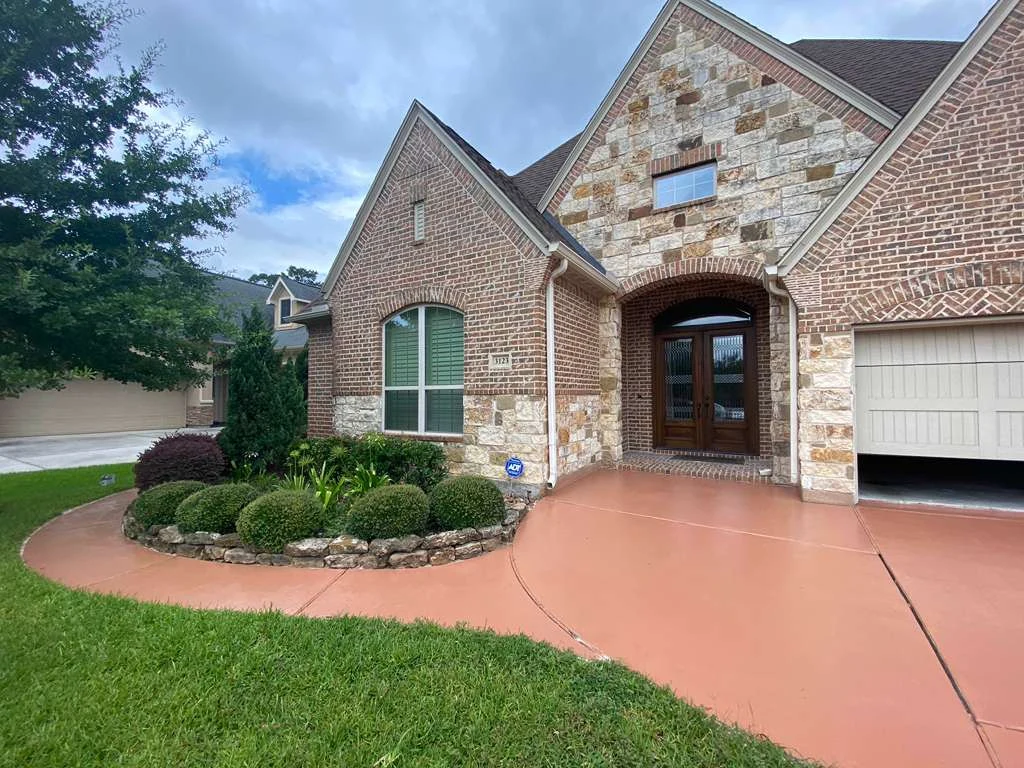 Stained concrete driveway and landscaped entrance